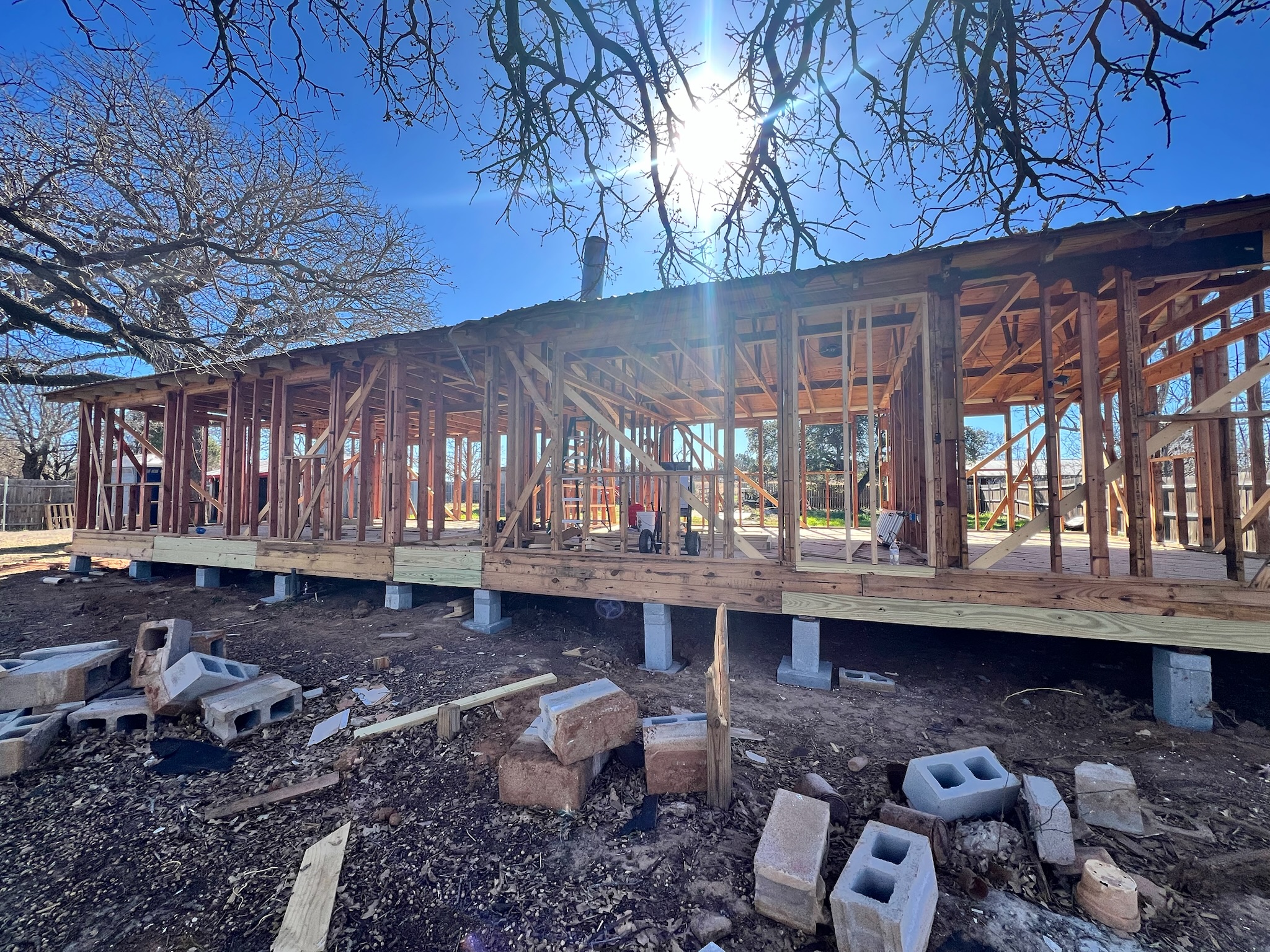The framed skeleton of the main house against a winter sky.